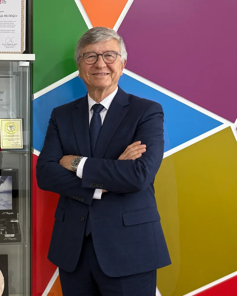 Geometrik renkli duvar önünde takım elbiseli hekim portresi